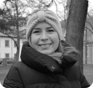 photo en noir et blanc d'une jeune femme souriante en vêtements d'hiver